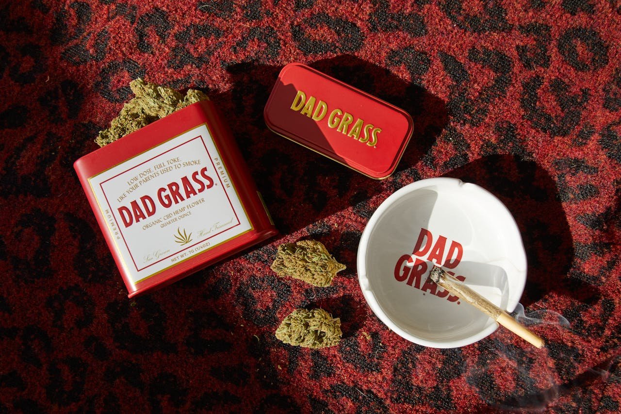 Cannabis products and accessories arranged on a vibrant carpet surface.